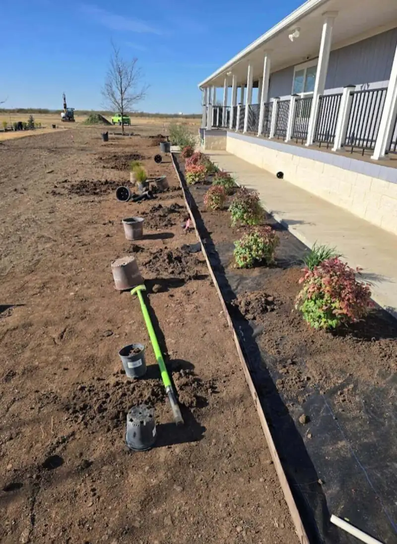 New flower bed planted along a porch with steel edging and drip irrigation